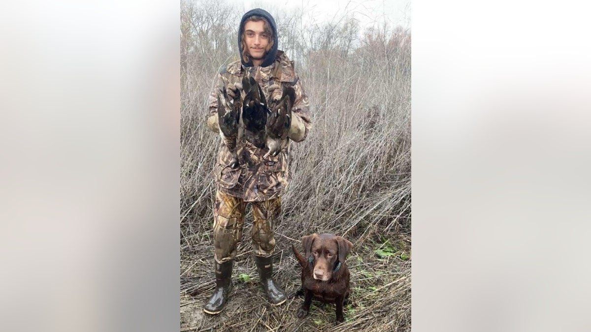 Wesley Cornett poses with birds and a dog