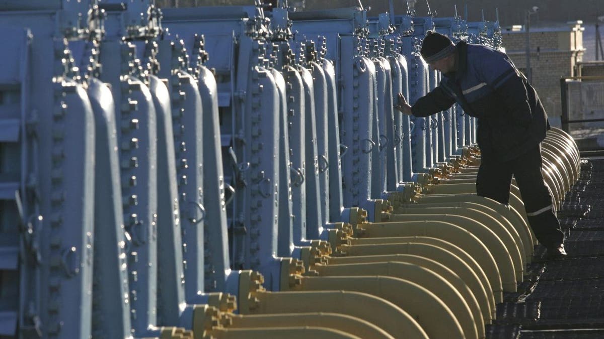 worker with equipment at gas compressor facility