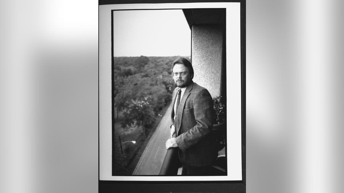 Tony Harper in a suit posing and looking serious.