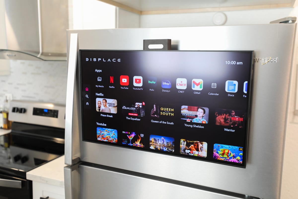 a TV hanging on the freezer door of a large fridge