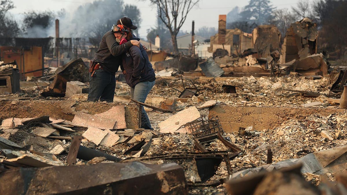 residents embrace amid wildfire rubble