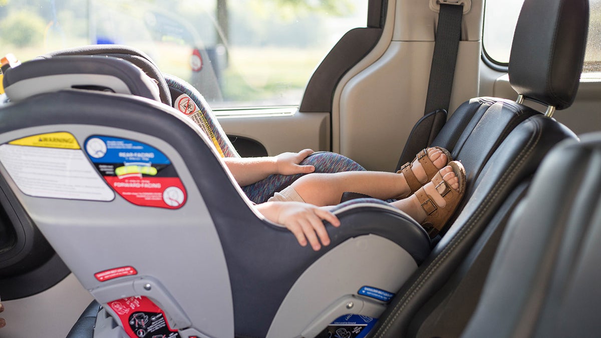 Child sits in car seat