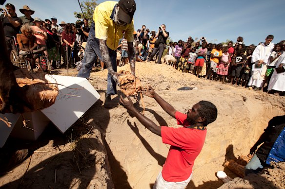 The paperbark wrapped human remains are lowered into the ground at Gunbalanya after they were returned to their ancestral home on July 19, 2011 for reburial after more than 60 years in the Smithsonian.