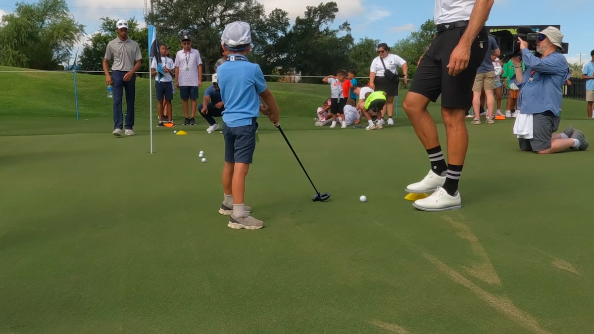 Children practice their golf swing with pros from the HyFlyer GC. 