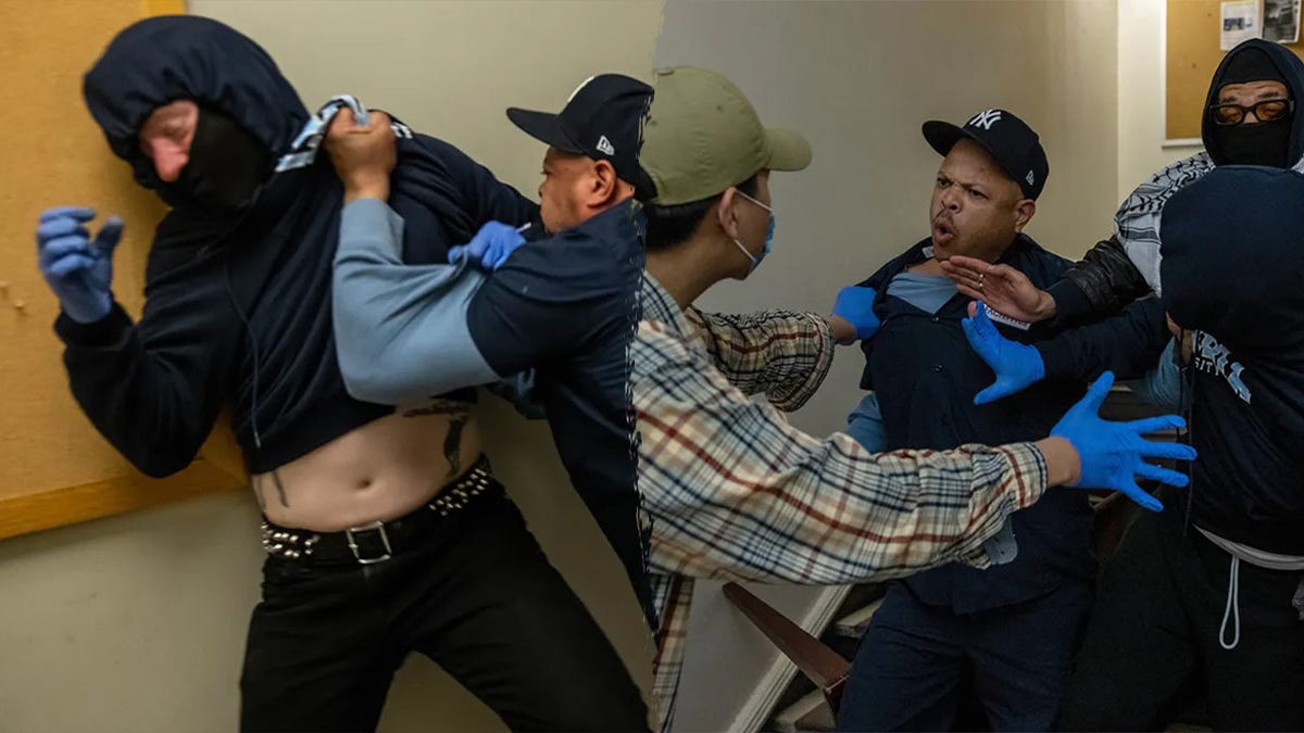 A Columbia maintenance worker fights with protesters