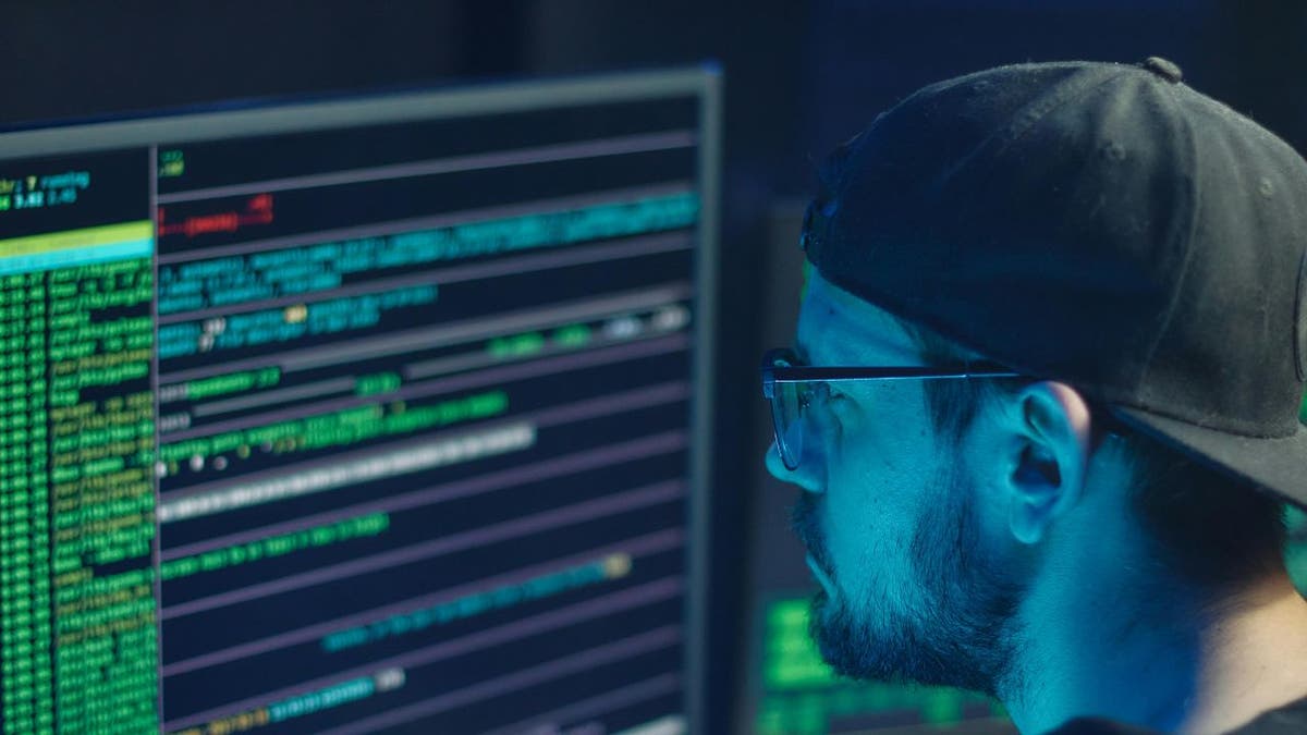 man in hat with computer screens