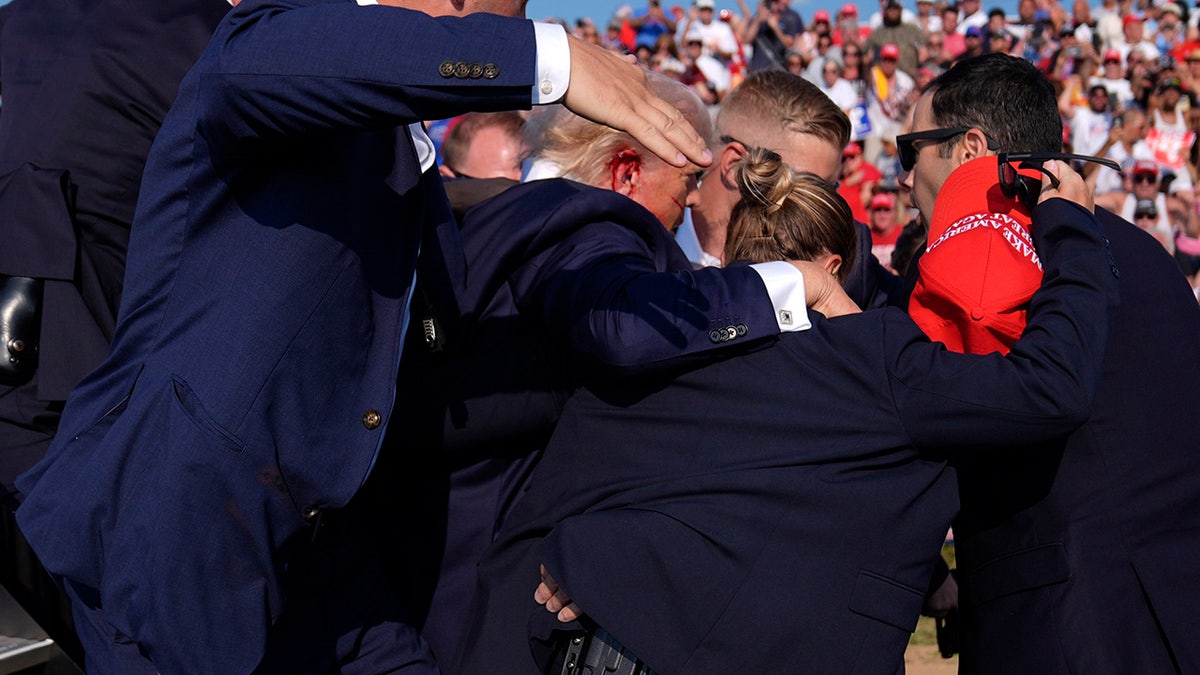 Donald Trump is surrounded by U.S. Secret Service agents at a campaign rally