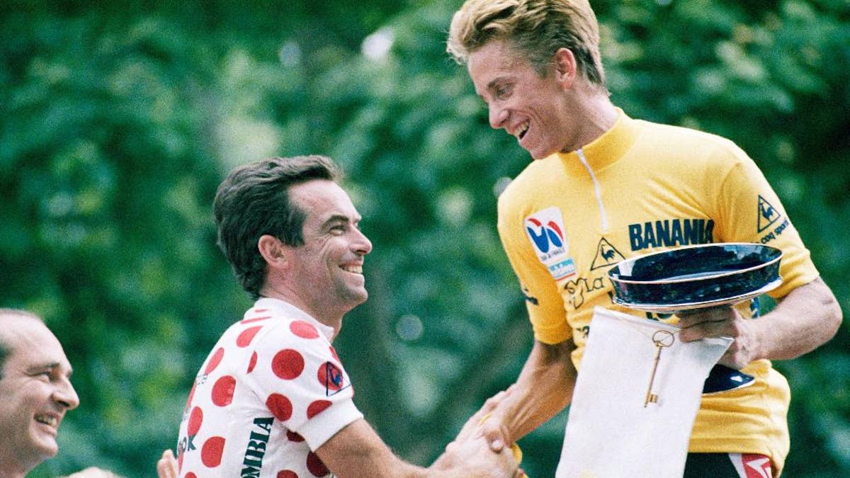 FILE - In this Sunday, July 27, 1986 file photo, five-time winner Bernard Hinault of France, left, congratulates Tour de France winner Greg Lemond of the United States in Paris. LeMond was at the peak of cycling in 1987 after becoming the first American to win the Tour de France the previous year. LeMond didn’t get to get defend his title in 1987 after being shot accidentally by his brother-in-law while they were turkey hunting. (AP Photo/Pierre Gleizes, File)