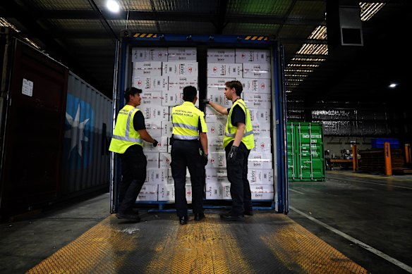 Australian Border Force officers with a container of illegal cigarettes in early 2024.