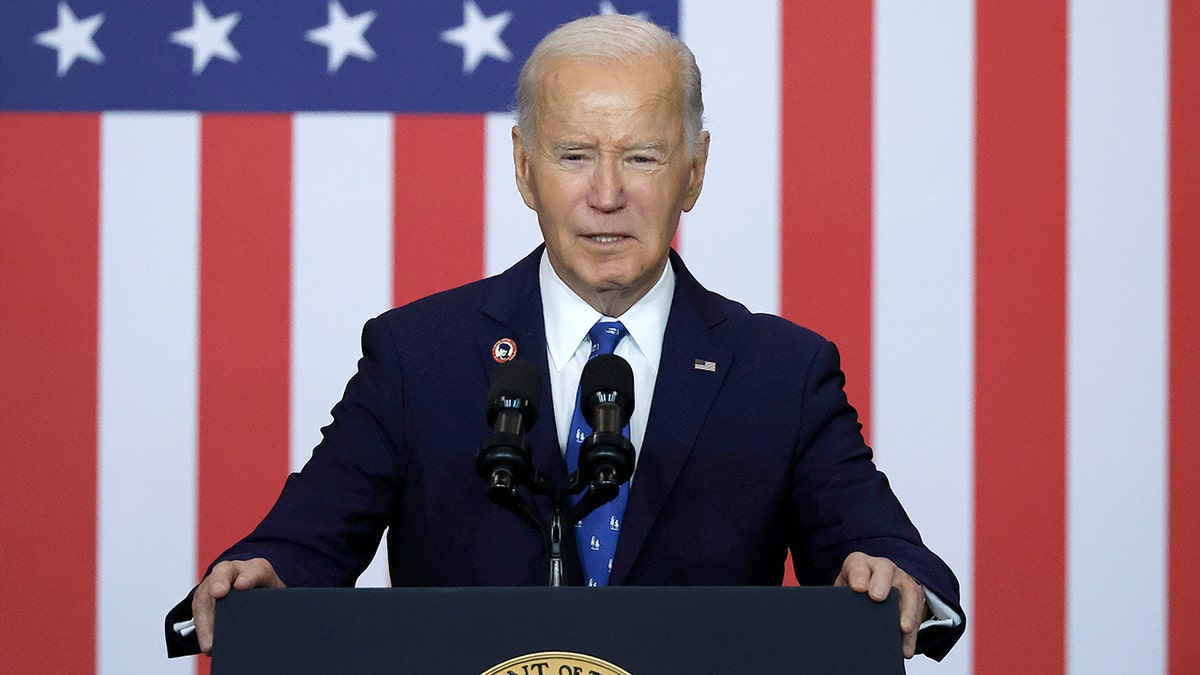 President Joe Biden standing in front of an American flag background