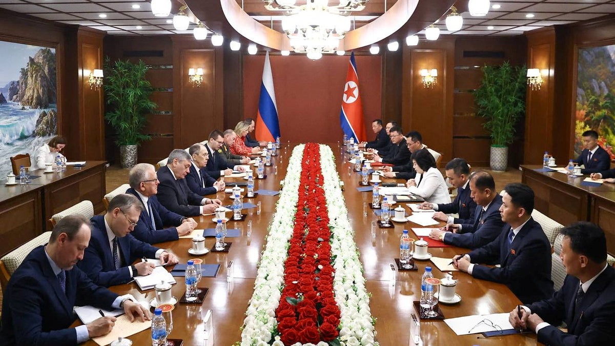 Sergei Levrov at a table with officals in North Korea