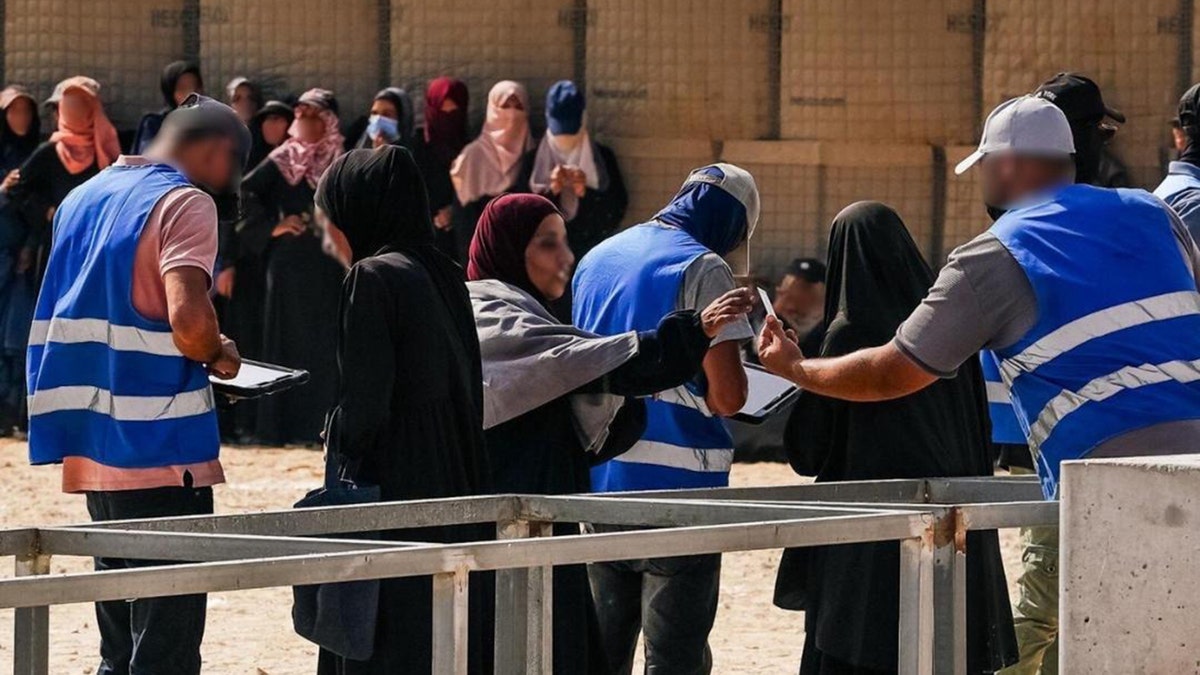 Women engage with Gaza Humanitarian Foundation (GHF) workers.