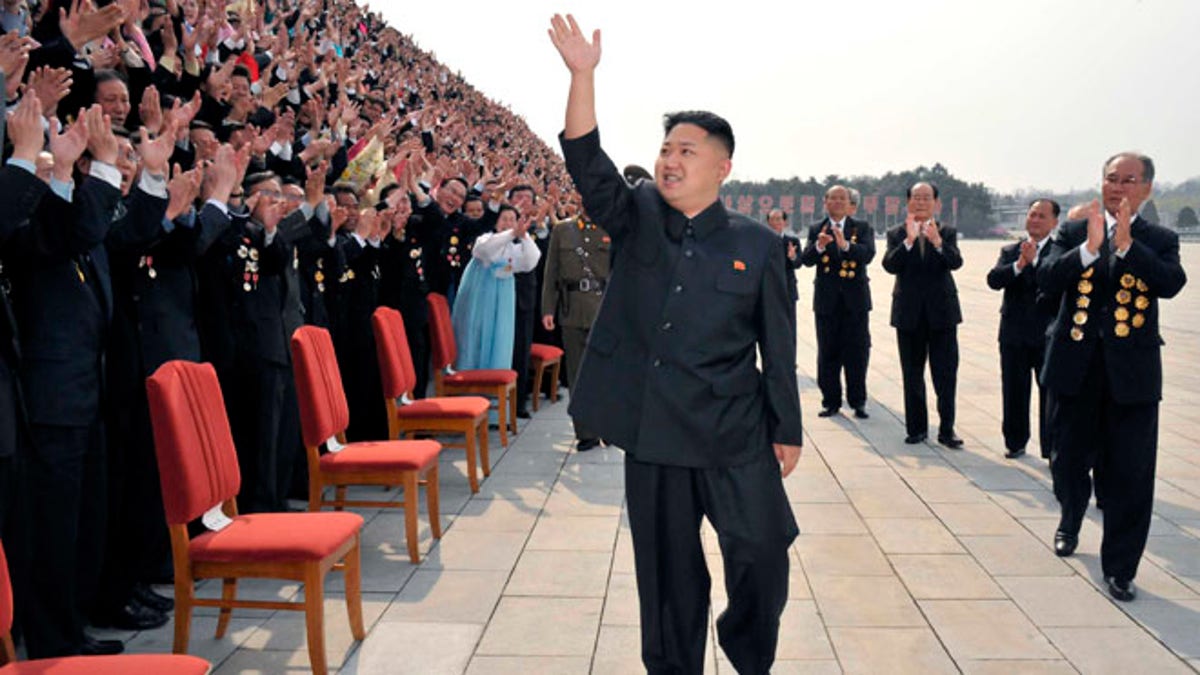 April 19: North Korean leader Kim Jung-Un waves as he arrives to take pictures with officials, creators and employees of the Mansudae Art Studio in Pyongyang.
