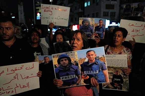 Protesters carry pictures of Palestinian journalists Anas al-Sharif and Mohamed Qreiqeh, who were killed by Israel this week.