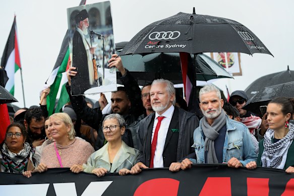Julian Assange and Craig Foster took part in the pro-Palestinian rally across the Sydney Harbour Bridge on August 3. In the background, a protester carries a picture of the Ayatollah Khomeini.