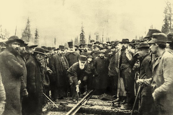Sandford Fleming, white-bearded and top-hatted, stands behind the (similarly kitted out) Canadian Pacific Railway president Donald Smith, who is driving the final spike into the transcontinental railway in Canada in 1885.