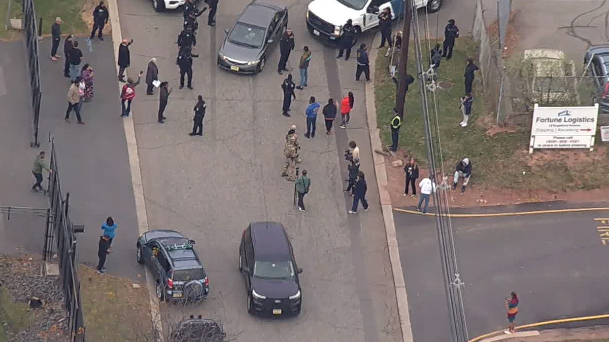 dozens of people wait outside near vans in surveillance footage