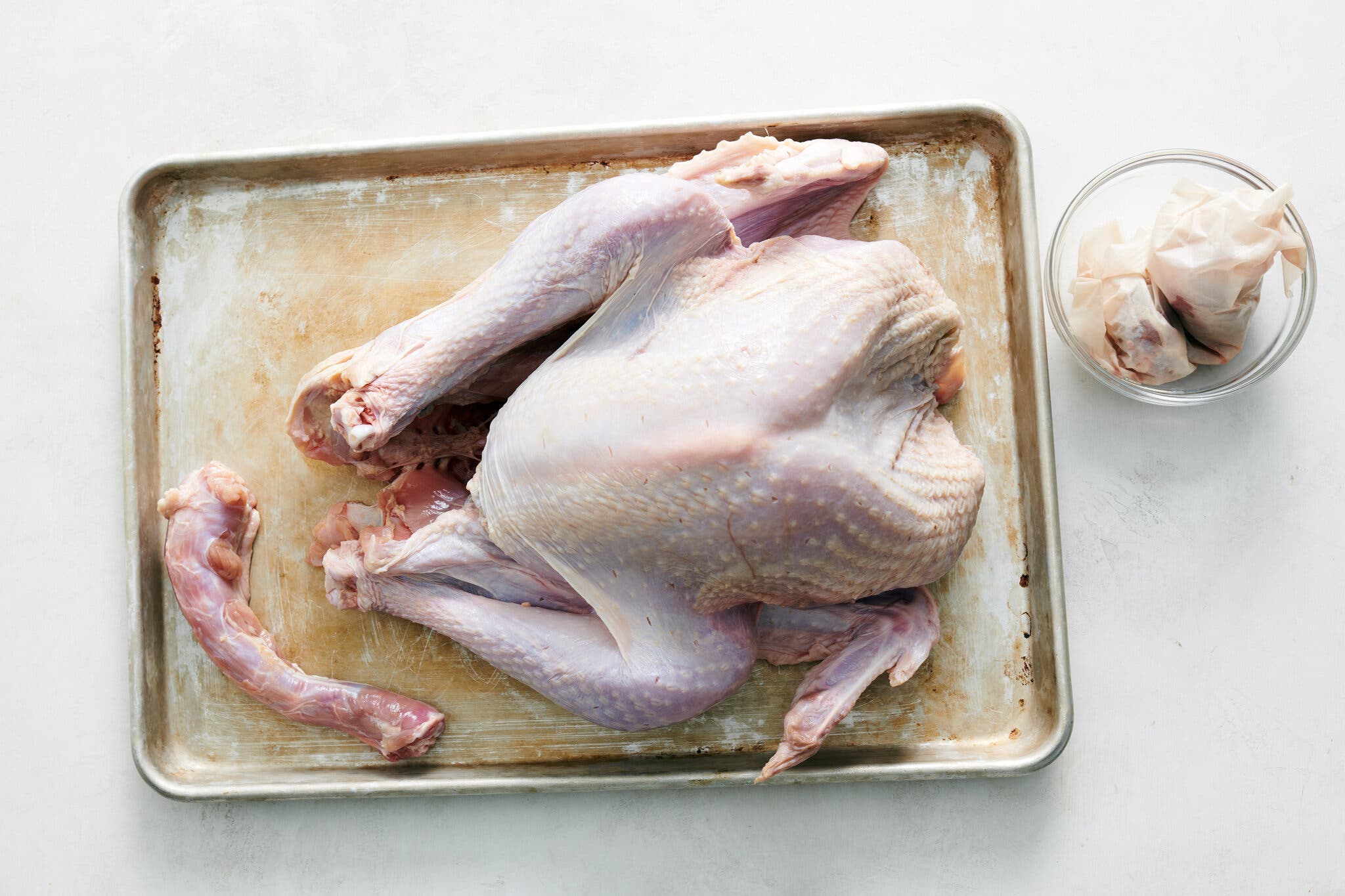 An overhead image of a raw turkey with the giblets and neck removed.