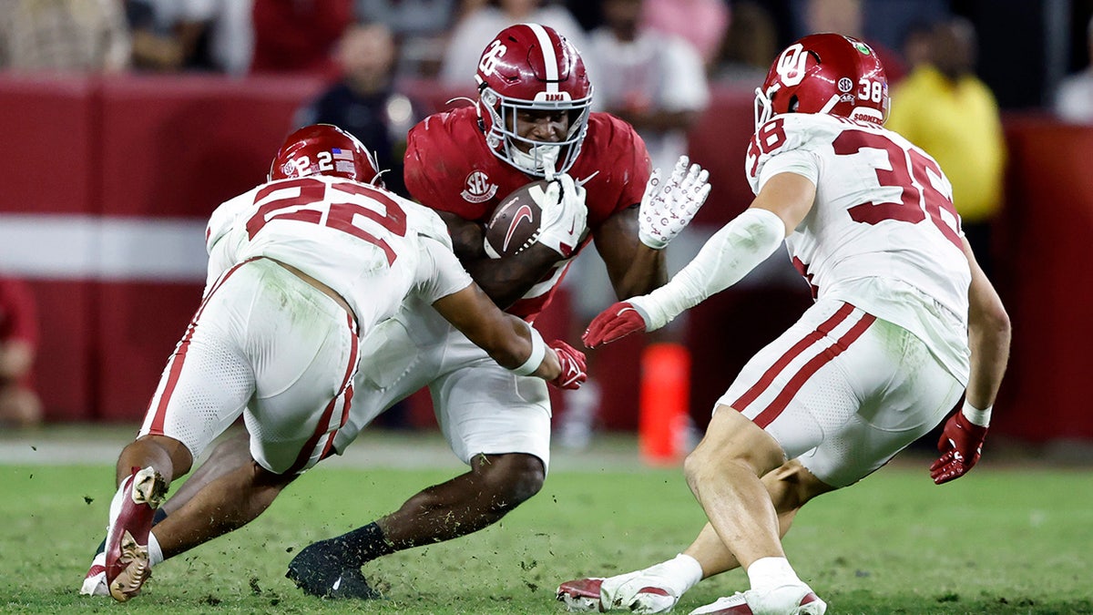 Oklahoma players tackle an Alabama player