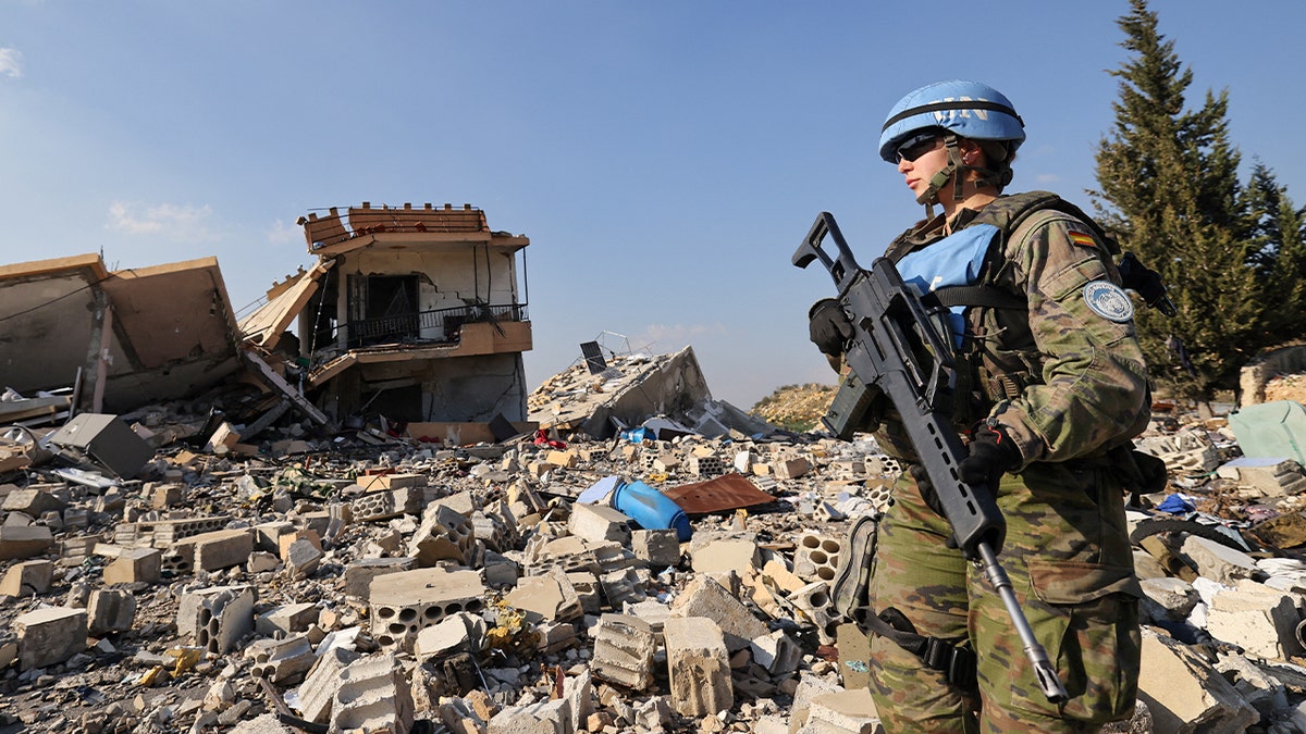 A member of the Spanish UNIFIL peacekeepers forces stands in front of the rubble of destroyed buildings during a patrol in the southern Lebanese village of Borj El Mlouk, near the border with Israel, on January 7, 2025, amid a fragile truce between Israel and Hezbollah.
