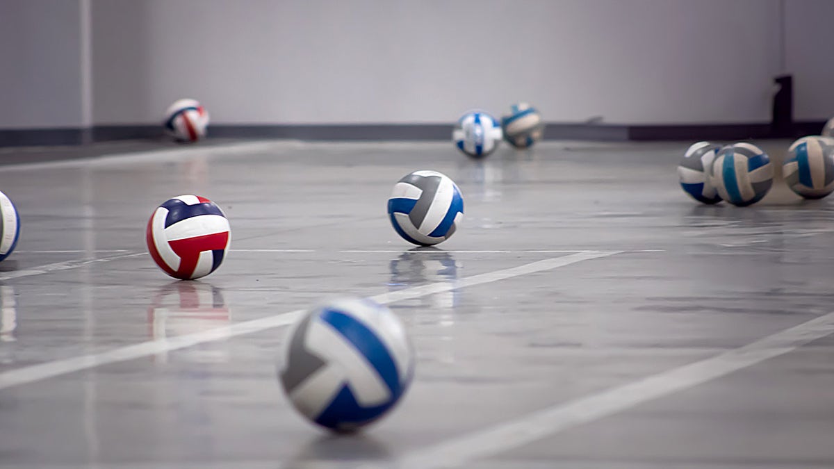 Volleyballs spread out on court