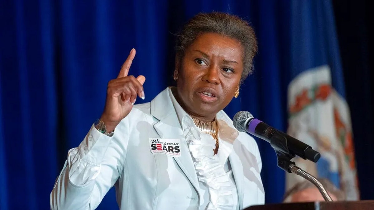 Winsome Sears points from podium