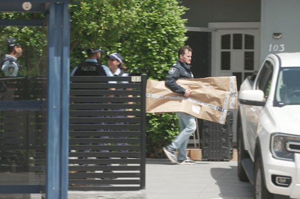 Police removing evidence from a short-term rental at Campsie.