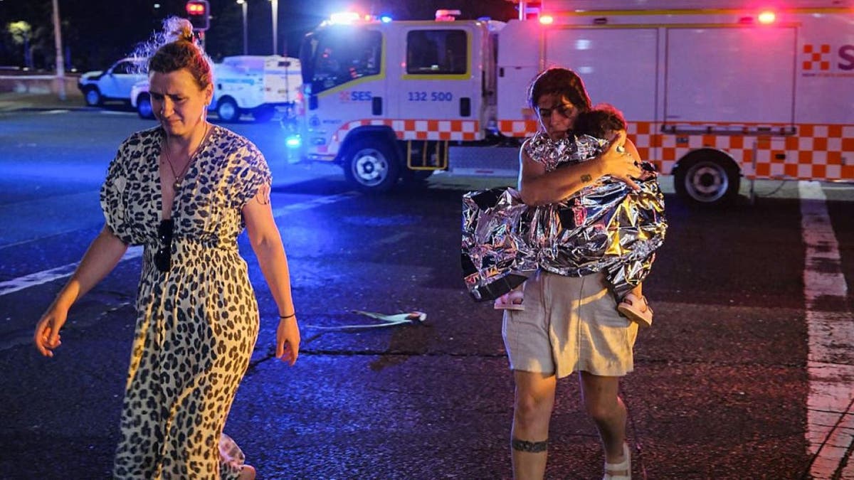 Two women and a child leave the scene of a shooting