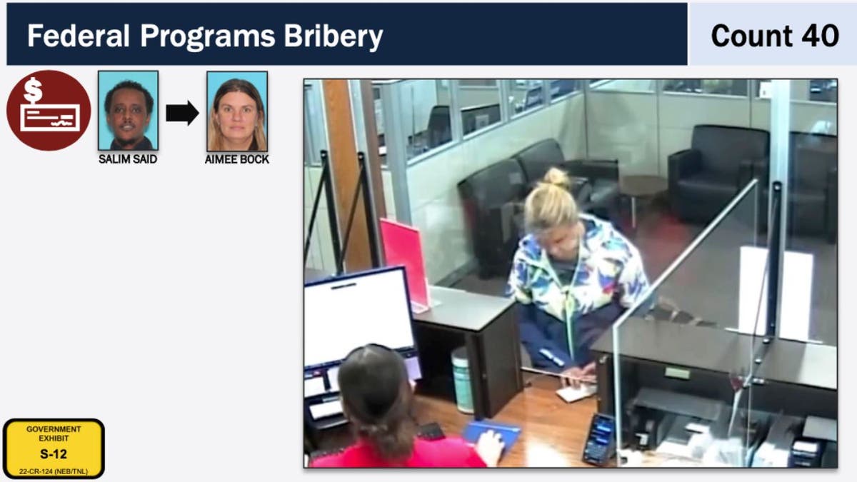 Aimee Bock at a bank counter in DOJ exhibit showing a $30,000 cash withdrawal.