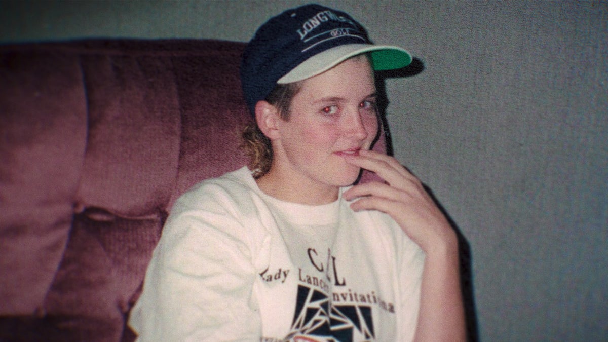 Amy Bradley wearing a white shirt with black print and a cap.
