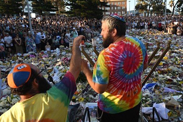 The Menorah is lit for the fourth night of Hanukkah in front of mourners at Bondi Beach yesterday.