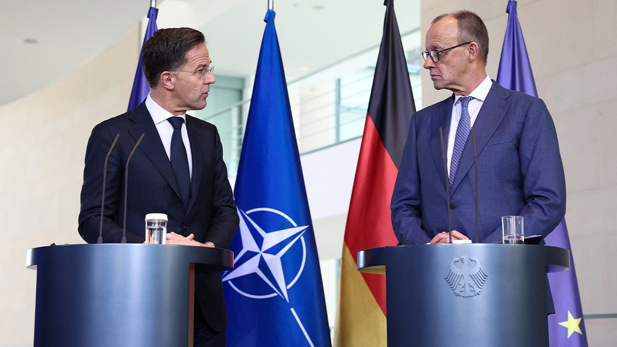 Germany’s chancellor and NATO’s chief speak side-by-side at a formal press briefing.