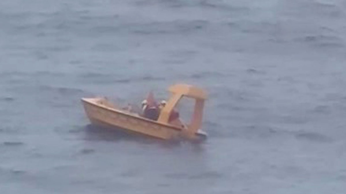 Father and daughter being rescued in small yellow boat