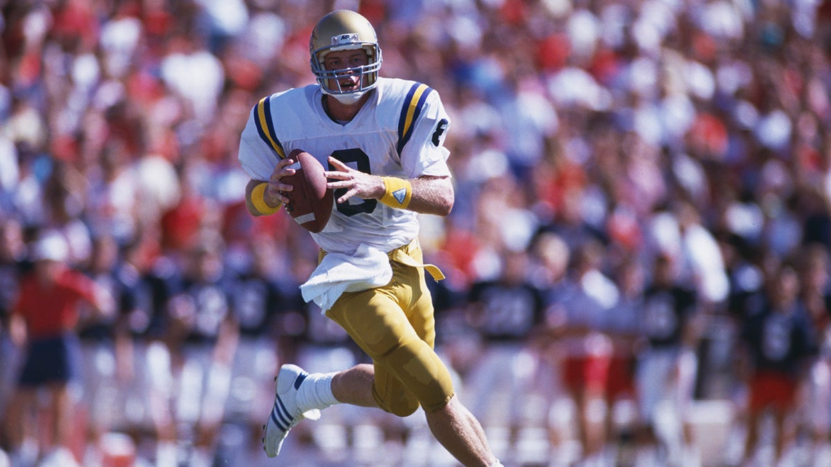 Troy Aikman runs during a football game.