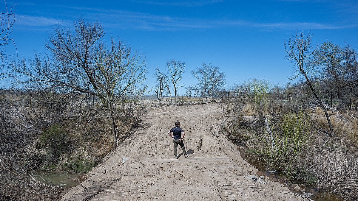 Man standing while looking at dry land.