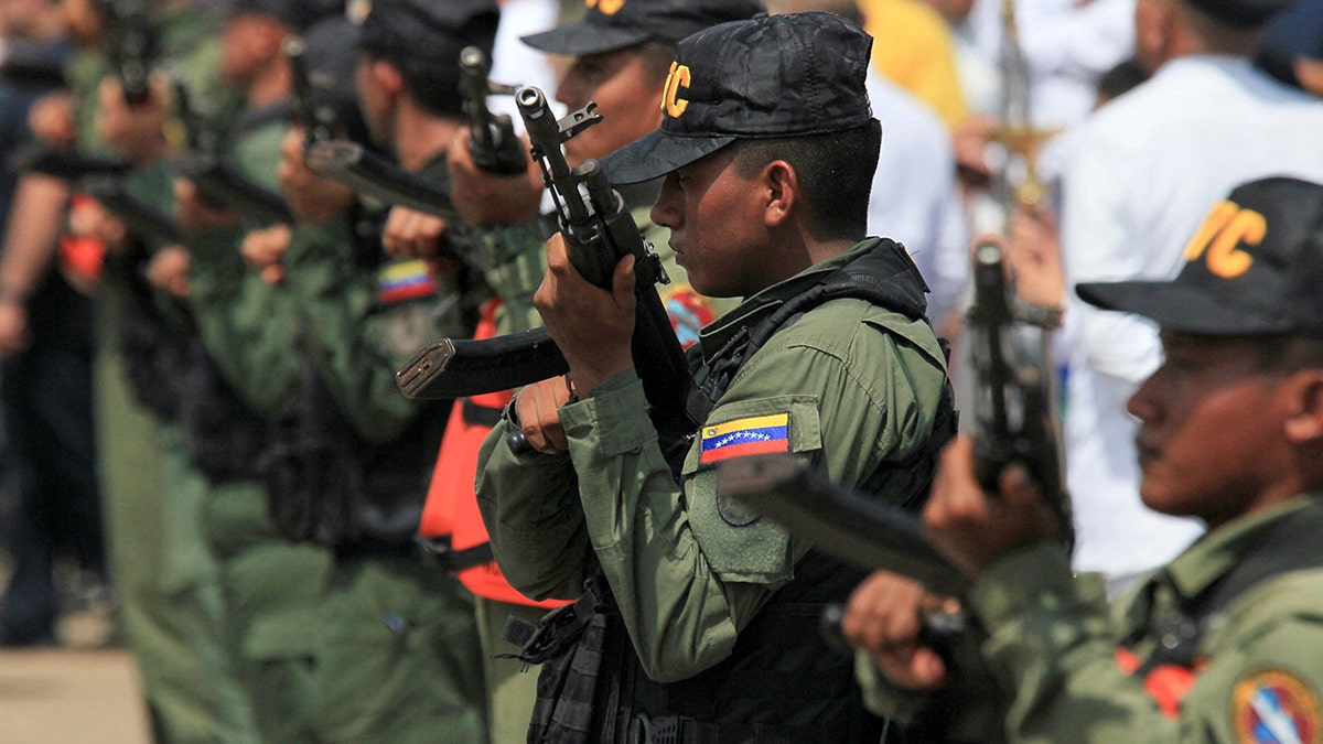 Members of Venezuela's Bolivarian National Guard hold weapons