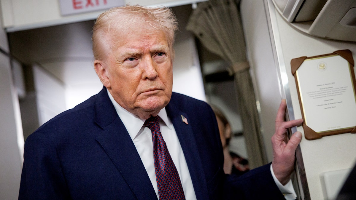 The president stands in the aisle of Air Force One.