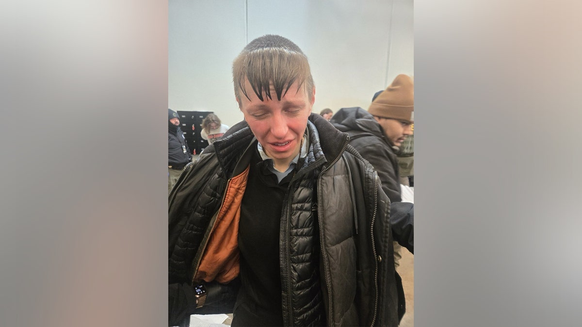 Person crying dressed in black jacket.