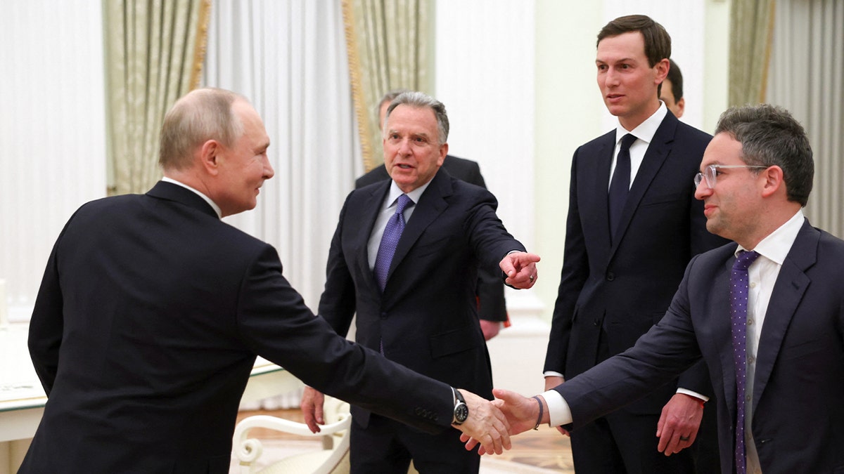 Russia’s president stands alongside U.S. representatives during a formal meeting inside a government setting.