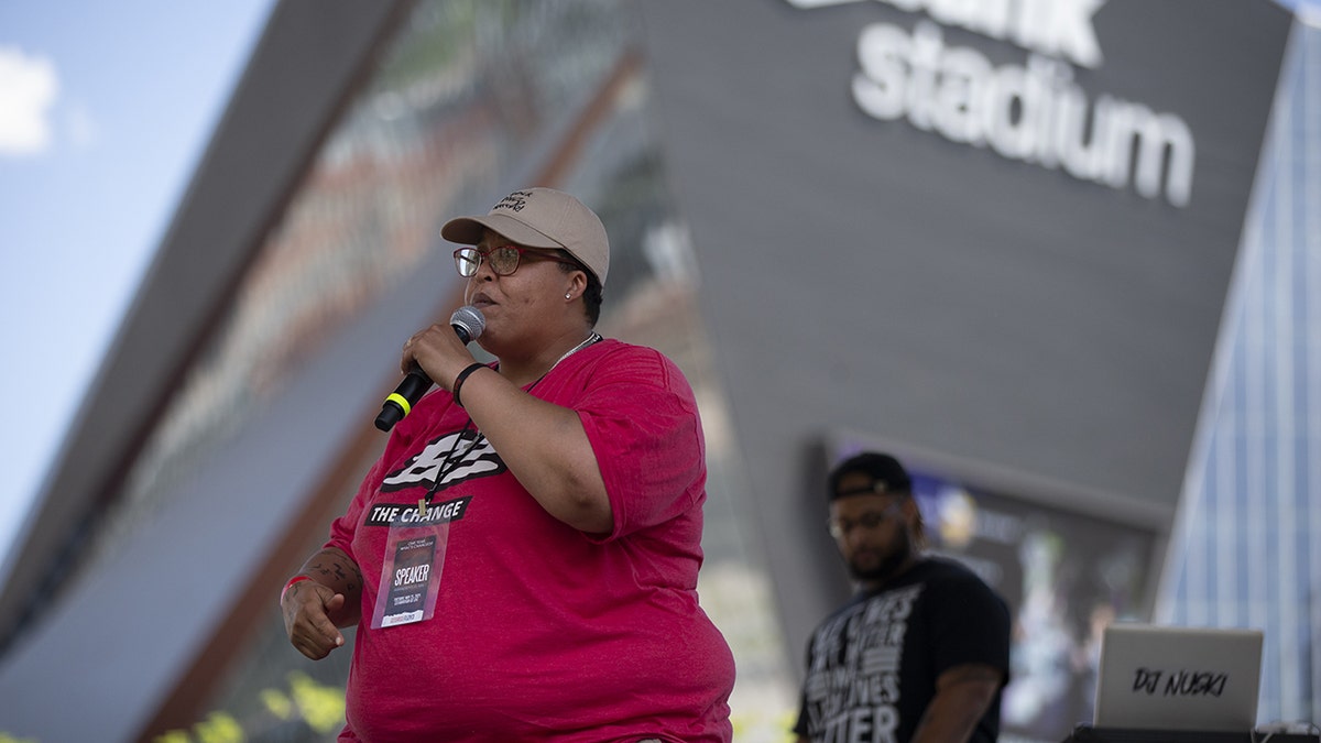 Chauntyll Allen BLM activist red shirt holding microphone