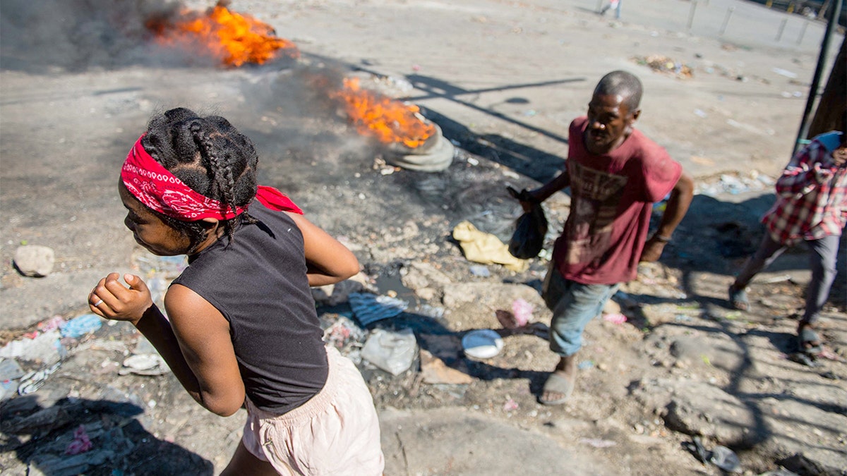 Demonstrators march through smoke-filled streets during protests over insecurity in Port-au-Prince.