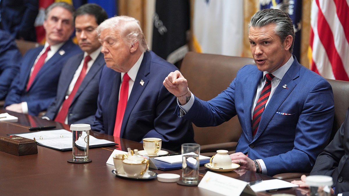 Secretary of War Pete Hegseth gestures while speaking alongside President Donald Trump at Cabinet meeting