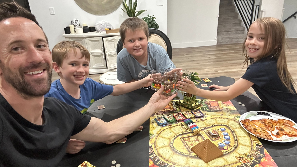 A father sits with three children inside a home in an undated photo