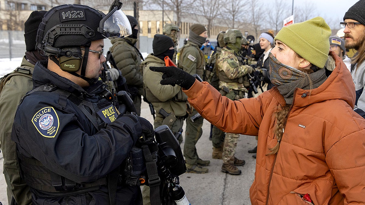 A protester confronts a Homeland Security officer during a demonstration outside a U.S. Immigration and Customs Enforcement facility amid heightened tensions in Minneapolis.