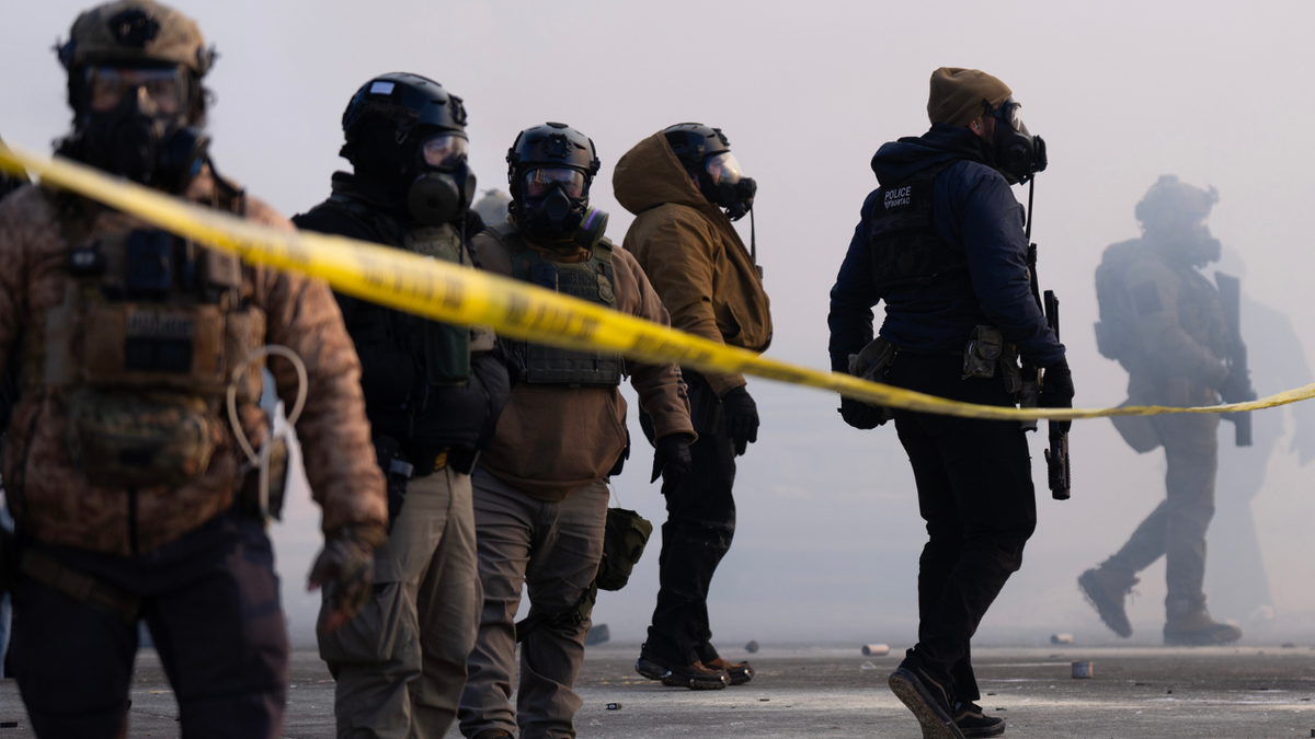 Federal agents face protesters after Alex Pretti was fatally shot by federal agents in the area early Saturday morning, January 24, 2026.