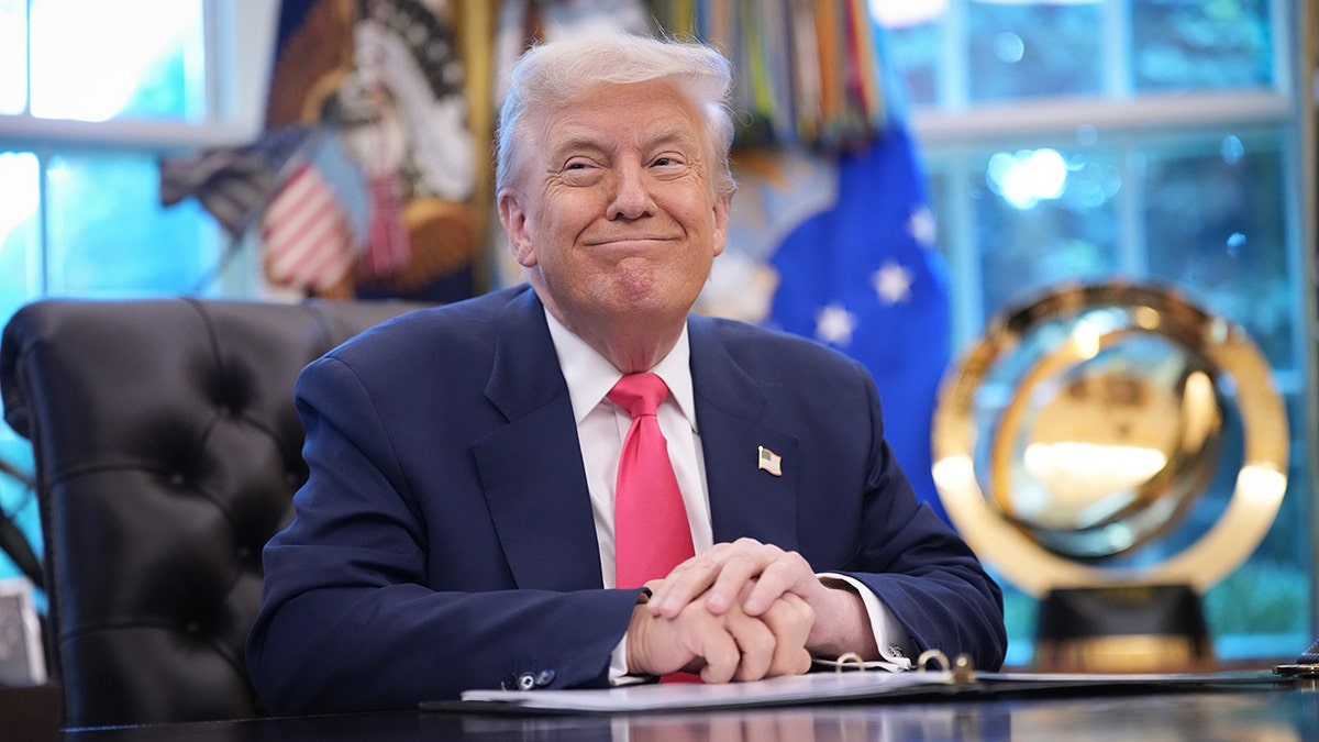 President Donald Trump smiling in the Oval Office.