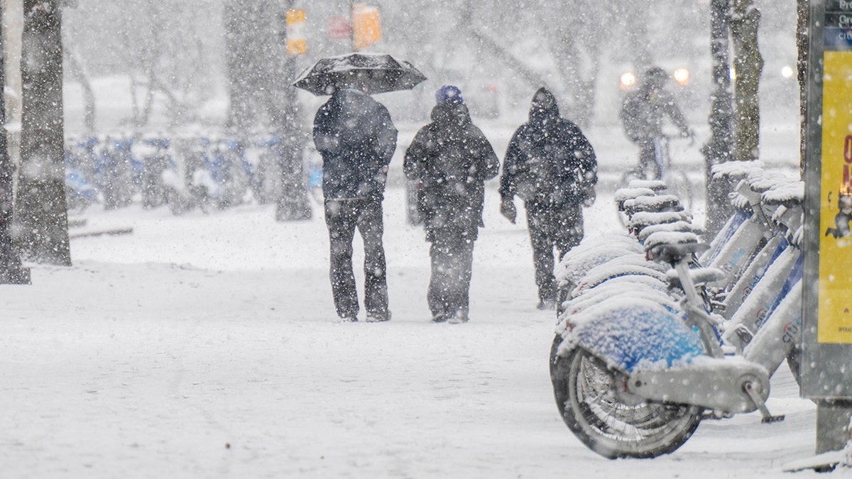 People walk as snow falls in Brooklyn