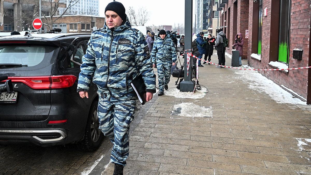Police walk past building in Moscow