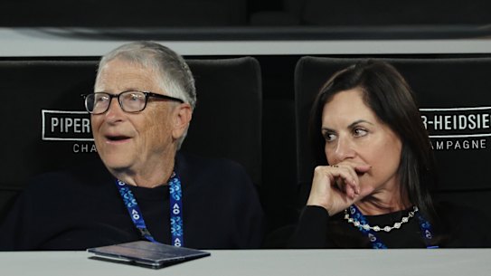 Bill Gates and Paula Hurd watch on Rod Laver Arena during the men’s doubles final.