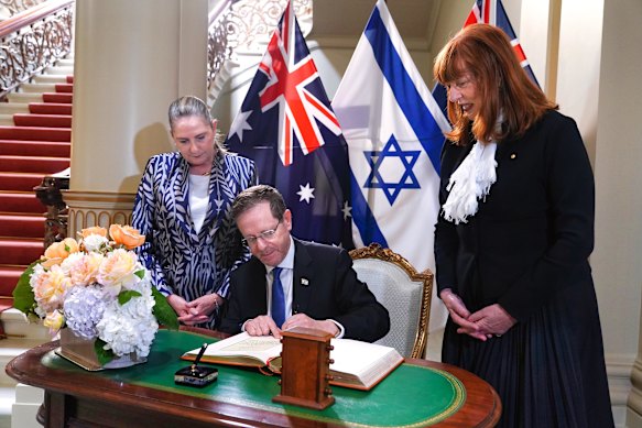 Israeli President Isaac Herzog signing the Government House guest book.